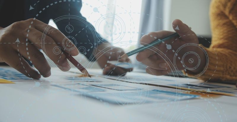 Two professionals reviewing a project plan at a desk